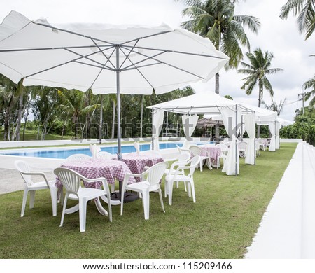 white deck chairs side swimming pool.
