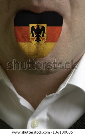man with open mouth spreading tongue colored in germany flag as symbol of values like teaching, learning, multilingual speaking of different languages