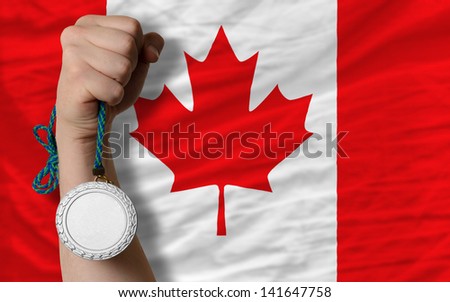 Holding silver medal for sport and national flag of canada