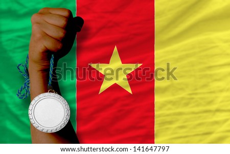 Holding silver medal for sport and national flag of cameroon