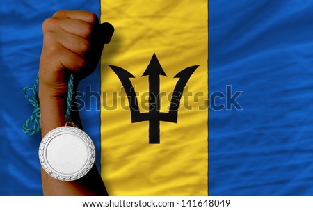 Holding silver medal for sport and national flag of barbados