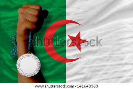 Holding silver medal for sport and national flag of algeria