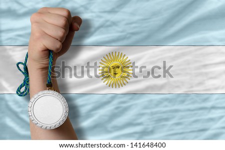 Holding silver medal for sport and national flag of argentina