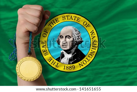 Winner holding gold medal for sport and flag of us state of washington