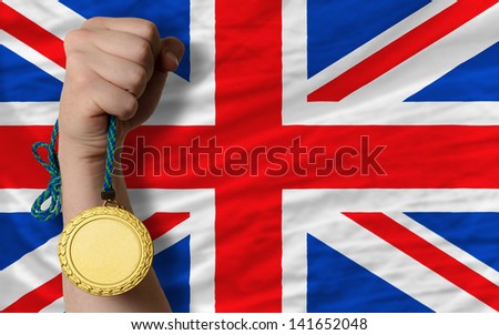 Winner holding gold medal for sport and national flag of uk