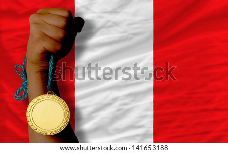 Winner holding gold medal for sport and national flag of peru