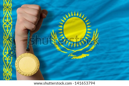 Winner holding gold medal for sport and national flag of kazakhstan