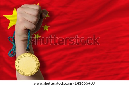 Winner holding gold medal for sport and national flag of china