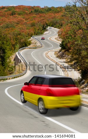 traveling car in national flag of germany colors and beautiful road landscape for tourism and touristic adertising