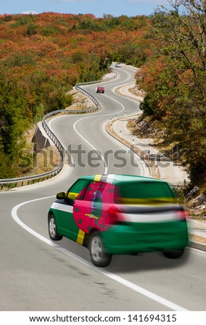 traveling car in national flag of dominica colors and beautiful road landscape for tourism and touristic adertising