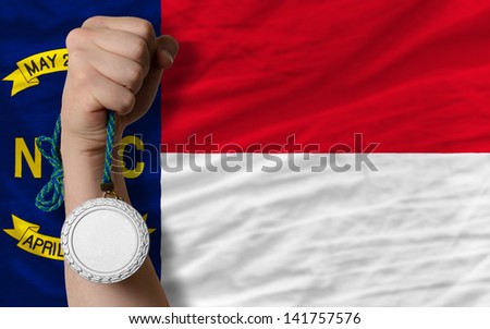 Holding silver medal for sport and flag of us state of north carolina