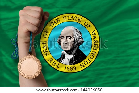 Holding bronze medal for sport and flag of us state of washington