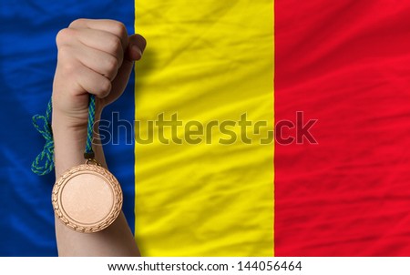 Holding bronze medal for sport and national flag of romania