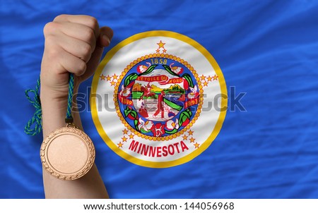 Holding bronze medal for sport and flag of us state of minnesota