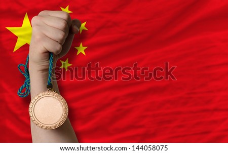 Holding bronze medal for sport and national flag of china
