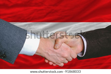 businessmen handshake after good deal in front of austria flag