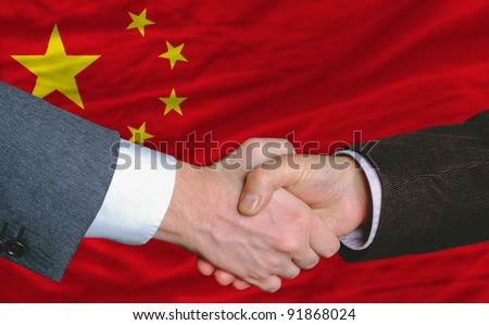 businessmen handshake after good deal in front of china flag