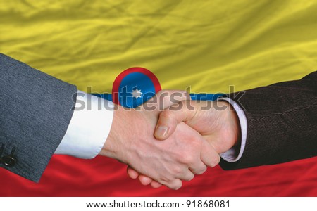 businessmen handshake after good deal in front of columbia flag