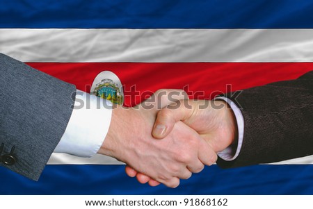 businessmen handshake after good deal in front of costa-rica flag