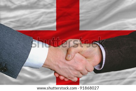 two businessmen shaking hands after good business investment  agreement in england, in front of flag