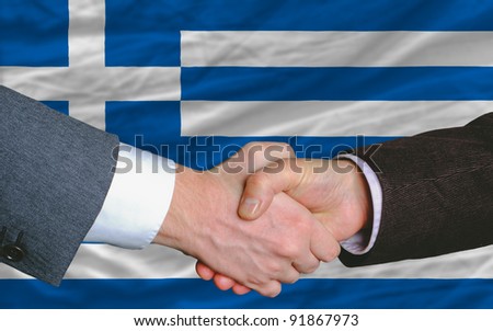 two businessmen shaking hands after good business investment  agreement in greece, in front of flag