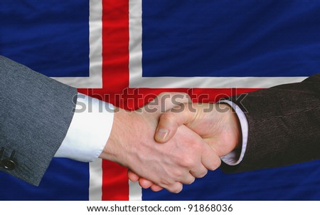 two businessmen shaking hands after good business investment  agreement in iceland, in front of flag