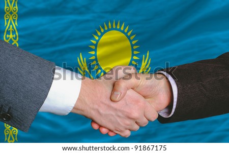 two businessmen shaking hands after good business investment  agreement in kazakhstan, in front of flag