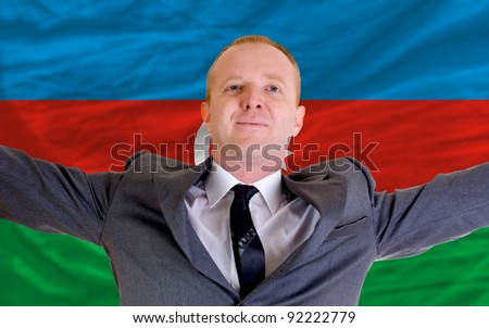 joyful investor spreading arms after good business investment in azerbaijan, infront of flag
