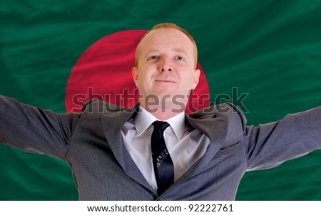joyful investor spreading arms after good business investment in bangladesh, in front of flag