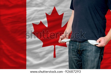 poor man showing empty pockets in front of canada flag