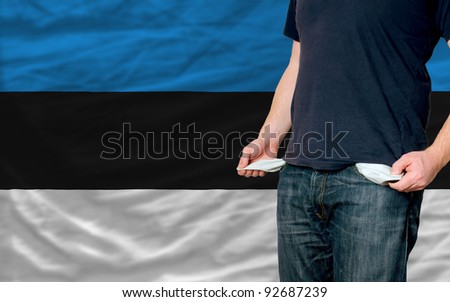poor man showing empty pockets in front of estonia flag