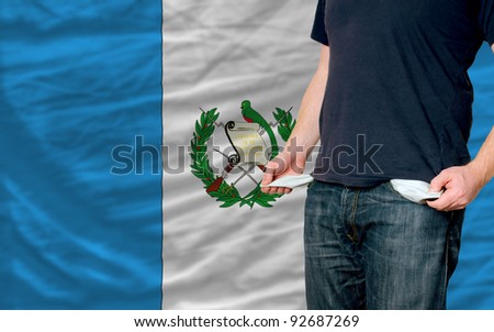 poor man showing empty pockets in front of guatemala flag