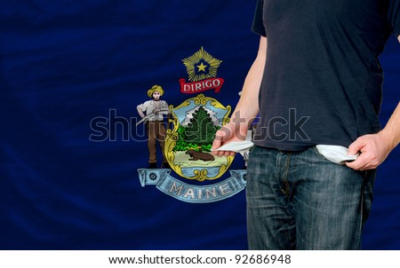 poor man showing empty pockets in front of american state of maine flag