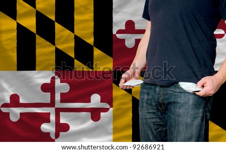 poor man showing empty pockets in front of american state of maryland flag