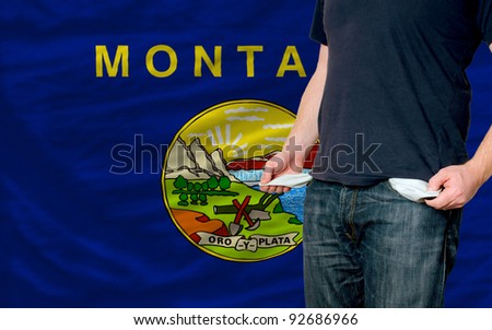 poor man showing empty pockets in front of american state of montana flag