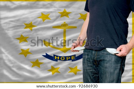 poor man showing empty pockets in front of american state of rhode island flag