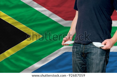 poor man showing empty pockets in front of south africa flag
