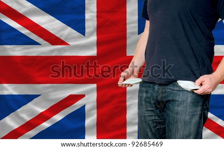 poor man showing empty pockets in front of uk flag