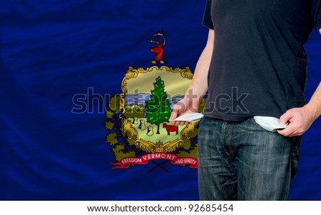 poor man showing empty pockets in front of american state of vermont flag