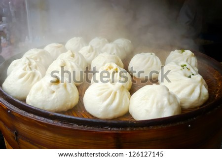 Chinese dumplings being steamed on the traditional bamboo pan