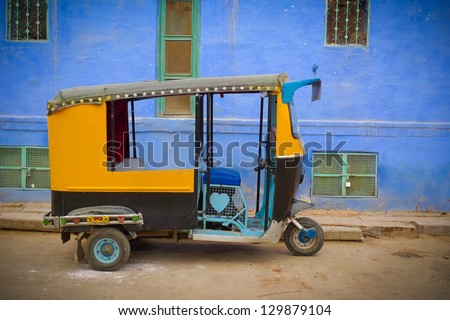 Traditional motorized rickshaw against a blue wall in Jodhpur, Rajasthan, India