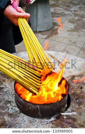 Prayers burning incense sticks on a temple fire in Shanghai, China