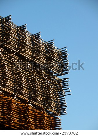 Stacked reinforcing rods, new over rusty ones, angled view with sky