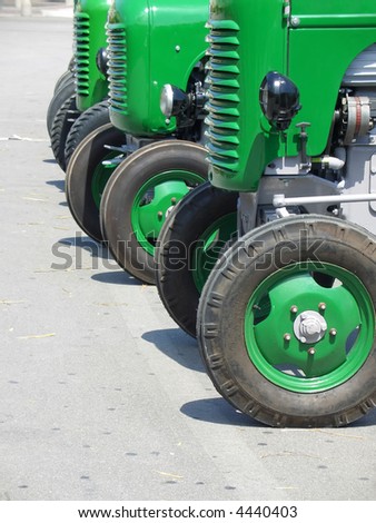 Detail of green vintage tractors lined up in a farming expo