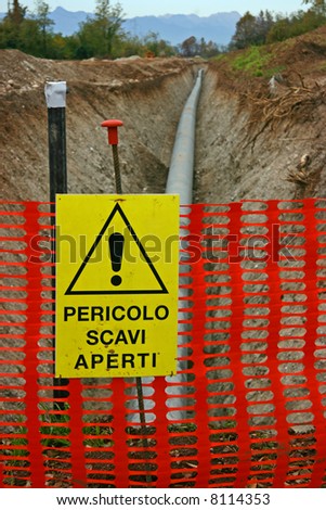 Work in progress burying gas pipe in a country area, danger sign reads \