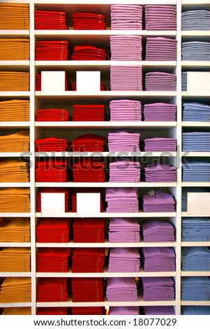 Colored polo shirts on display in a shop. Blank description tags.