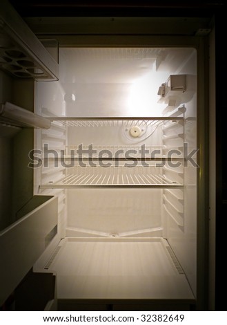 Interior of an empty fridge lit by the internal lamp