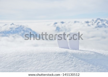 Two blank winter sport ski pass tickets on mountain top. Concept to illustrate winter sport admission fee