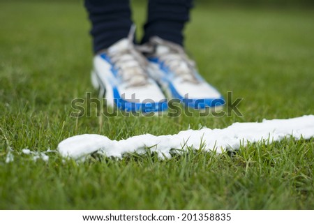Soccer player standing at foam spray free kick line