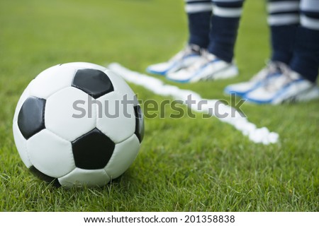 Wall of two soccer player standing behind foam spray free kick line